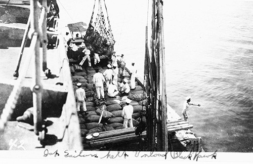 NH 100371: USS Blackhawk (AD-9). Japanese sailors help unload the ship after her arrival in Tokyo Bay with relief supplies for victims of the Great Kanto Earthquake in September 1923. NHHC Photograph Collection.
