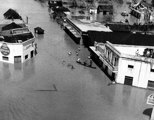 330-PS-7528 (USN 651156):  Flood Victims Wade Through Streets.   Flood victims at Panuco, Mexico, wade through flood waters in the downtown streets.    USS Saipan (CVL 48) loaded with helicopters, food, medical supplies and Navy doctors arrived at Tampico, Mexico, October 1, 1955, to lend aid to the Mexican area left devastated and flooded by Hurricane Janet.   Official U.S. Navy Photograph, now in the collections of the National Archives.  