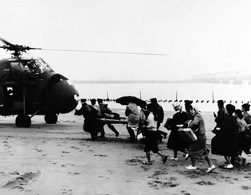 330-PS-9711 (428-GX-710555):  Victims of Typhoon Vera rush towards a U.S. Navy Helicopter to be evacuated from the flooded area.  The rescue took place in Toshiyama Village, Nagoya, Japan, 7 October 1959.  Official U.S. Navy Photograph, now in the collections of the National Archives.     