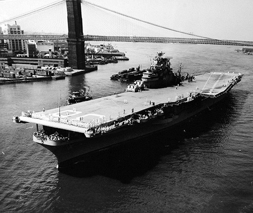80-G-626628:  USS Antietam (CVA 36) passes under Brooklyn Bridge on way to Brooklyn Navy Yard, New York City, New York. Photographed August 3, 1953.  U.S. Navy photograph, now in the collections of the National Archives.
