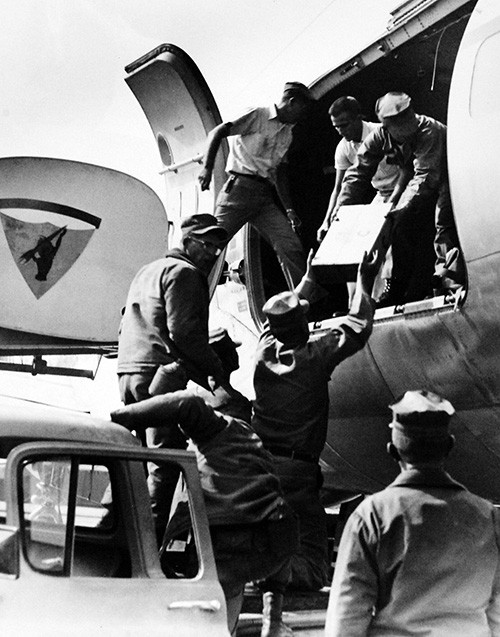 330-PSA-75-64 (USN 1093135):  U.S. Navy Seabees load their tools and equipment aboard aircraft at Point Mugu, California, as they prepare to depart for Alaska.  The group, consisting of 152 men from Mobile Construction Battalion Nine, is composed of electrical and utilities specialists.  They will help restore these essential services to parts of Alaska that suffered such severe damages in the recent earthquakes and tidal waves.  Other Navy planes have been carrying shipments of food, clothes, portable generators, heating units, and living supplies to the people of Alaska.  Photograph released March 31, 1964.  Official U.S. Navy Photograph, now in the collections of the National Archives.  