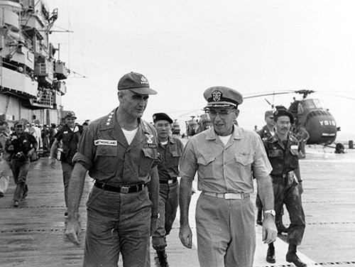 NH 93798:  USS Princeton (LPH-5), General William Westmoreland, COMUSMACV (left), with Captain Paul J. Knapp, USN, Commanding Officer of Princeton, on the ship’s flight deck, on the occasion of her delivery of food relief supplies to South Vietnam.   NHHC Photograph collection. 
