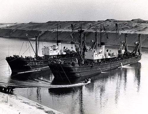 Navy Heavy Lift Craft (YHLC’s) Crilley (left) and Crandall at work on the wreck of the Egyptian Dredge #23 at the kilometer 72 mark on the Suez Canal.  Photographed by PH3 Dwain Patton, USN.   NHHC Photograph Collection, Navy Subject Files. 