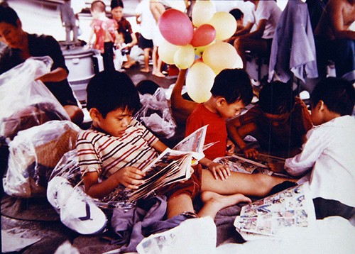 428-GX-K-130903:   South China Sea.  Vietnamese children relax and look at comic books on the deck of USS Towers (DDG-9), shortly after their rescue from a small boat found adrift.  Photographed by PH3 Kenneth Flemings, received May 3, 1981.      Official U.S. Navy Photograph, now in the collections of the National Archives.   