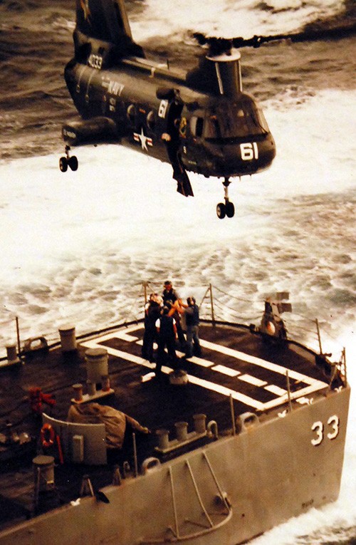 428-GX-K124382:   South China Sea.  A CH-46D “Sea Knight” helicopter of Helicopter Combat Support Squadron 11, HC-11, hovers over the after deck of the guided-missile destroyer USS Parsons (DDG-33) to take on board 21 Vietnamese refugees who were rescued from small craft by the destroyer.   The Sea Knight is from the replenishment oiler USS Wabash (AOR-5) and will take the boat people to the oiler before processing before they are transported to Subic Bay, Republic of the Philippines.  Photographed by PH2 Felimon Barbante, Jr.,  August 4, 1979.   Official U.S. Navy Photograph, now in the collections of the National Archives.   