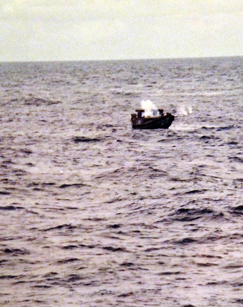 428-GX-K130898:   South China Sea.  Water sprays up as shots are fired from the guided missile destroyer USS Towers (DDG-9) to sink the small boat from which Vietnamese refugees were just rescued.  Photographed by PH3 Kenneth Flemings, received May 3, 1981.    Official U.S. Navy Photograph, now in the collections of the National Archives.   