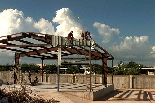 330-CFD-DD-SD-00-00694: Operation Restore Hope. U.S. Navy Seabees remove old metal sheathing from the frame of a building they will rebuild into a kitchen and dining facility at the U.S. Embassy compound in Mogadishu, Somalia. by PHCM Terry C. Mi...