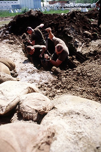 330-CFD-DD-ST-98-02272:   Operation Provide Promise.   U.S. Navy Seabees dig a trench at one of several sites being worked on at Camp Pleso.   Photograph received April 30, 1994.   Official Department of Defense photograph, now in the collections of the National Archives.   