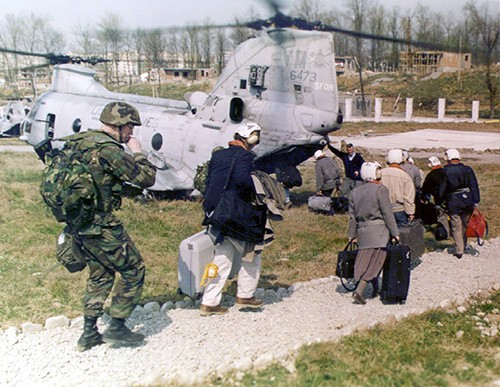 330-CFD-DM-SD-03-01193:   Operation Silver Wake.   American citizens are escorted to a CH-46E “Sea Knight” helicopter by a 26th Marine Expeditionary Unit (Special Operations Capable) Marine during the operation.  Twenty-Sixth Expeditionary Unit Marines were called upon to perform a Non-Combatant Evacuation of U.S. citizens that desire to leave Albania.   Photographed by SGT Mark D. Olivia, USMC, March 14, 1997    U.S. Marine Corps photograph, now in the collections of the National Archives.  
