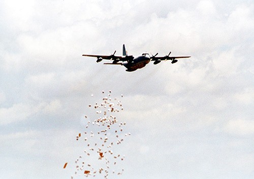 330-CFD-DM-SD-02-04707:  Operation Nobel Response.  A U.S. Marine Corps C-130 “Hercules” drops food on a drop zone in the north eastern province of Kenya.  Photographed March 6, 1998 by CPL M.A. Butler, USMC.  Official U.S. Marine Corps photograph, now in the collection of the National Archives.  