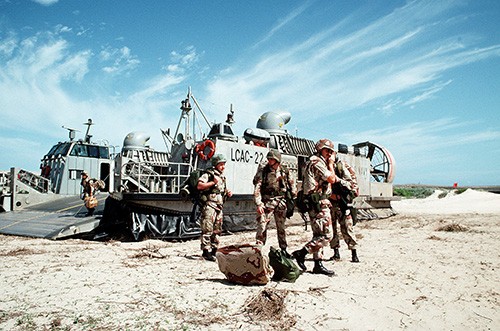 330-CFD-DN-ST-93-01401:   Operation Restore Hope.  U.S. Marines disembark from their air-cushion landing craft, LCAC-22 during the multinational relief effort.    Photographed by PHCM Terry C. Mitchell, December 15, 1992.   Official U.S. Navy photograph, now in the collections of the National Archives.   