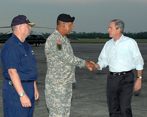 330-CFD-DN-SD-06-05785: Hurricane Katrina, 2005.   U.S. President George W. Bush (right) greets US Army Lieutenant General Russel L. Honore, Commander, Joint Task Force (JTF) Katrina, and US Coast Guard Vice Admiral Thad W. Allen, Director of Federal Emergency Management Agency (FEMA) Relief Efforts, on board Naval Air Station, Joint Reserve Base, (NAS JRB) New Orleans. Photographed on October 10, 2005 by PH2 William Townsend.  Official U.S. Navy Photograph, now in the collections of the National Archives.   