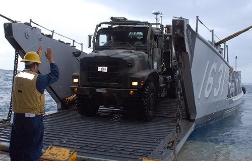 091118-N-T1311-026:   Boatswain’s Mate 2nd Class Carlos Gonzales guides a 7-ton Marine Corps truck to Landing Craft Utility 1631 from the well deck of USS Tortuga (LDS-46) while underway in the Philippine Sea.  Photographed November 18, 2009 by MC1 Geronimo Aquino. 