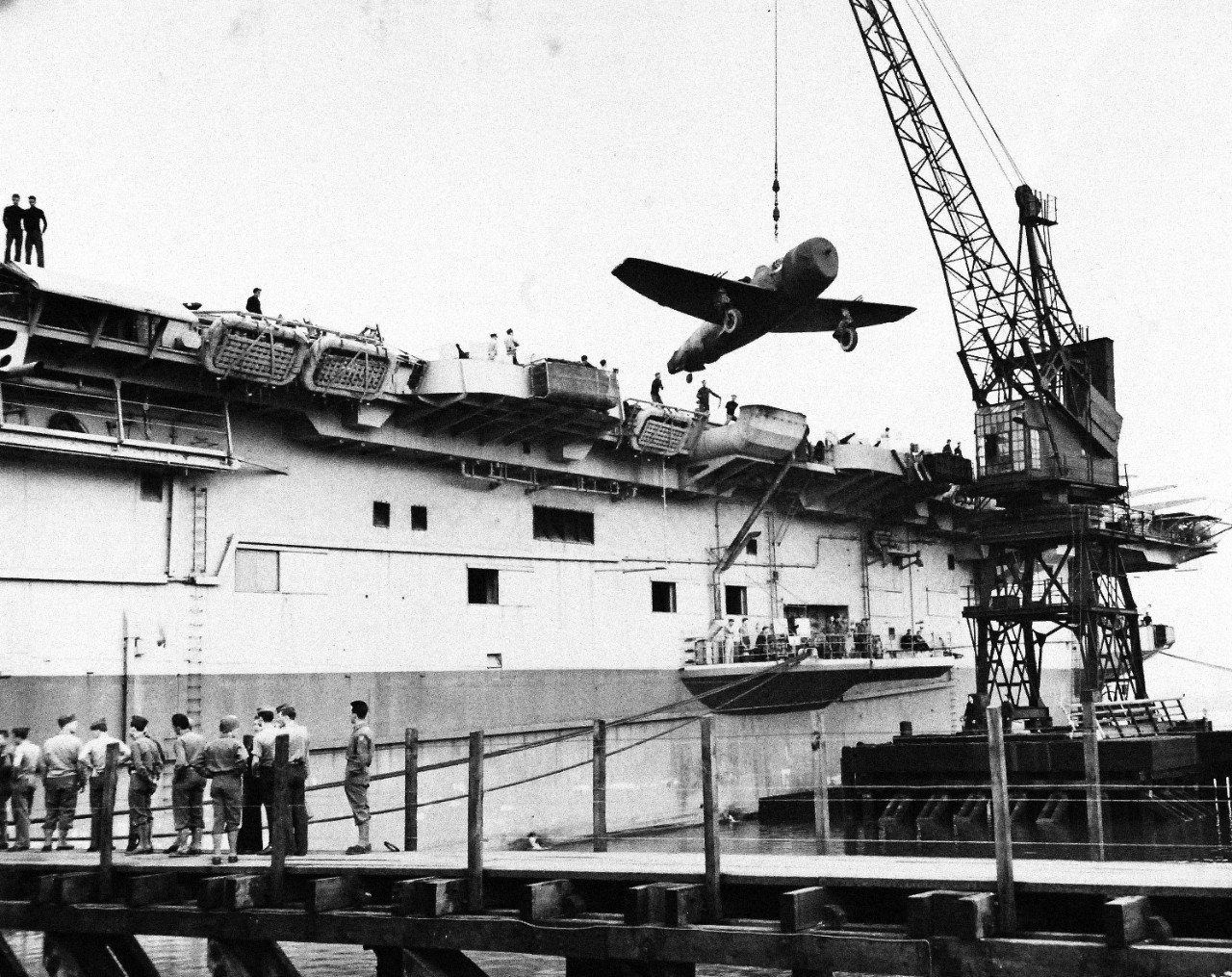 80-G-77763:  USS Block Island (CVE-21), 1943.   Unloading P-47’s at Belfast, North Ireland, July 27, 1943.  This image captures the hoisting of a plane from the flight deck.   Official U.S. Navy Photograph, now in the collections of the National Archives.  (2015/03/04). 