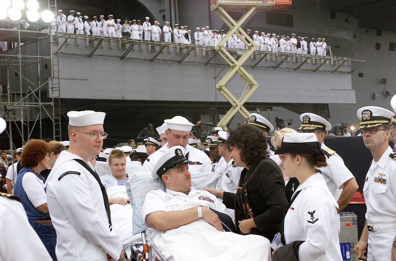 330-CFD-DN-SD-03-12954:  USS Cole (DDG-67), 2000.  Surviving sailors from the USS Cole (DDG 67) are comforted by shipmates and family members at a memorial service held at Pier 12, Naval Station Norfolk, Virginia, October 18, 2000.   Official U.S. Navy photograph, now in the collections of the U.S. National Archives.
