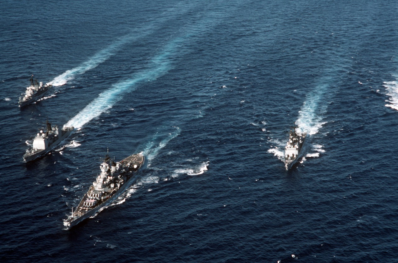 330-CFD-DN-ST-88-00265: USS Iowa (BB-61) and Battle Group in formation, 1987.     Ships left to right:   USS Dewey (DDG-45); USS Ticonderoga (CG-47); USS Iowa (BB-61) and USS Deyo (DD-989).   Photographed by PH2 Robert Sabo, September 17, 1987.  Official U.S. Navy photograph, now in the collections of the National Archives.   