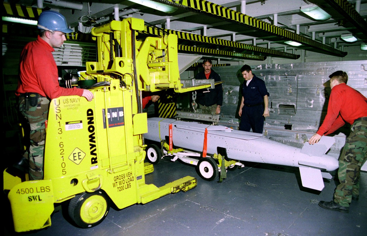 330-CFD-DN-SD-02-03126:  USS Enterprise (CVN-65), 2003.  US Navy Aviation Ordnancemen from the Weapons Department aboard USS Enterprise (CVN-65) position a recently received JSOW (AGM-154) weapon onto a skid for transport to the flight deck. Enterprise is forward deployed, operating in the Mediterranean, 3/5/1999.  PH2 Damon Moritz, USN.  Official U.S. Navy Photograph, now in the collections of the National Archives. 
