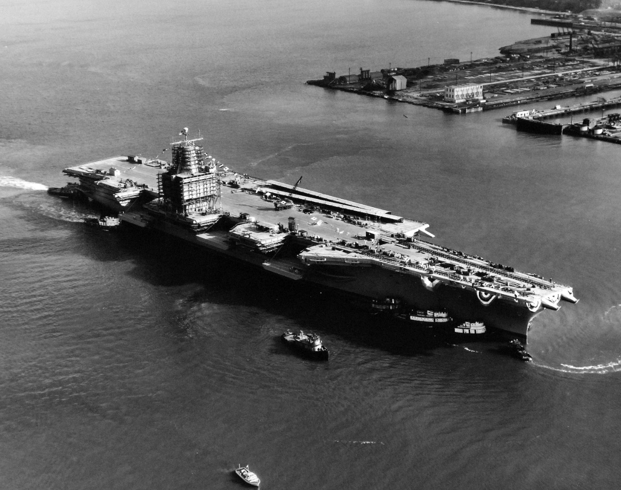 330-PSA-229-60 (USN 1050180):  USS Enterprise (CVN-65), 1960.   Aerial view of the launching at Newport News Shipbuilding and Drydock Company, Newport News, Virginia, September 24, 1960.   Shown:  Tugs move the aircraft carrier after launching.   Official U.S. Navy Photograph, now in the collections of the National Archives.   (2015/09/09).  