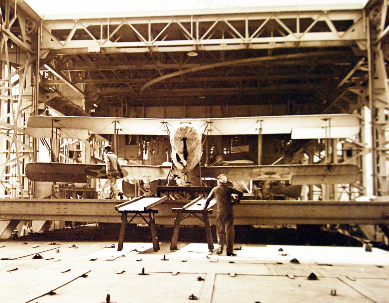 19-NS-L6:  USS Langley (CV 1),  1923.  Runways are shown in place with Vought AS-1 or VE-7, July 10, 1923.    Caption expansion, “Putting a small plane on the elevator, crew lands plane on after end of portable skids, then plane is pushed up incline on elevator by hand, a most unfortunate design.”  Official U.S. Navy photograph, now in the collections of the National Archives.   (2014/07/2) 