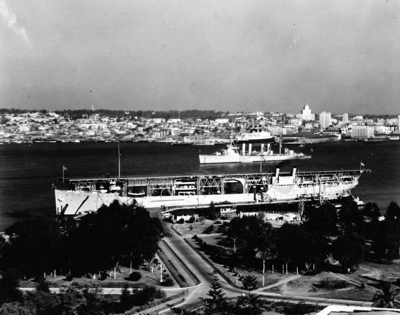 80-G-185892:   USS Langley (CV-1), 1931.    Langley in the foreground at San Diego, California, January 10, 1931.  Note the Red Star Liner Belgenland at Municipal Pier.  View taken from Air Tower at Naval Air Station, San Diego.  Official U.S. Navy photograph, now in the collections of the National Archives.  (2015/12/22). 