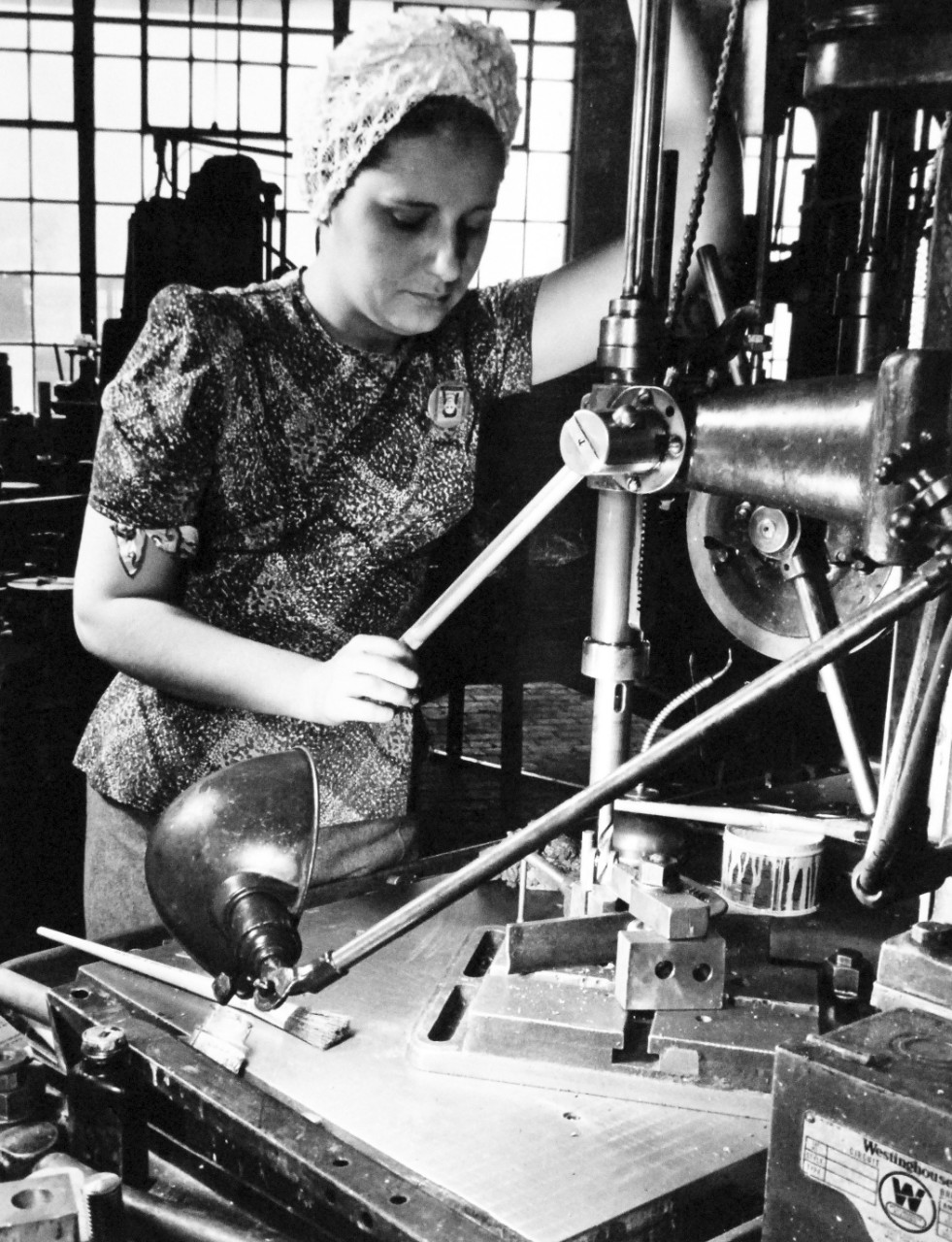 U.S. Naval Gun Factory, Washington Navy Yard, 1943.  Shown:  Woman ordnance worker performing first operation in the production of a gun detail on a multiple spindle drill press.  Photograph released March 20, 1943.   Official U.S. Navy photograph, now in the collections of the National Archives.