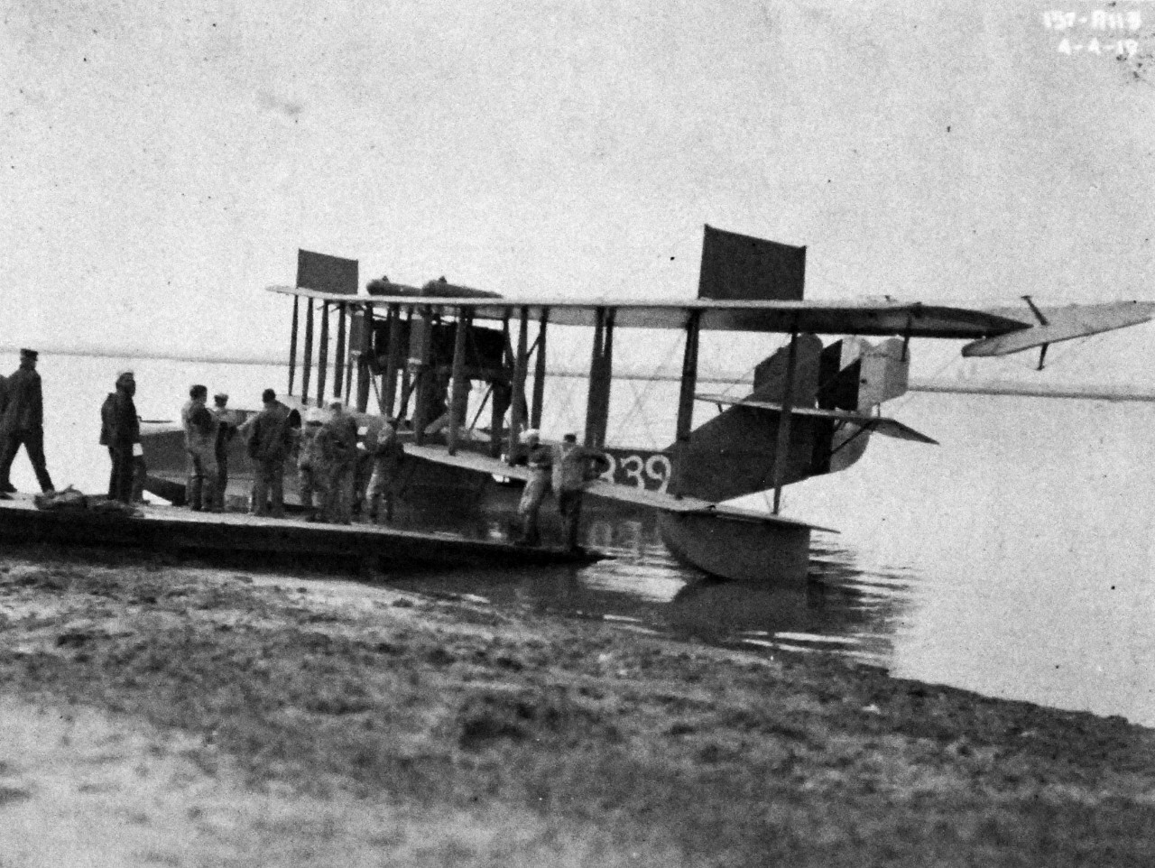 <p>80-G-1021:&nbsp;&nbsp;&nbsp;&nbsp; H-16 on the shore with sailors attending to the aircraft, April 4, 1919.&nbsp;</p>
