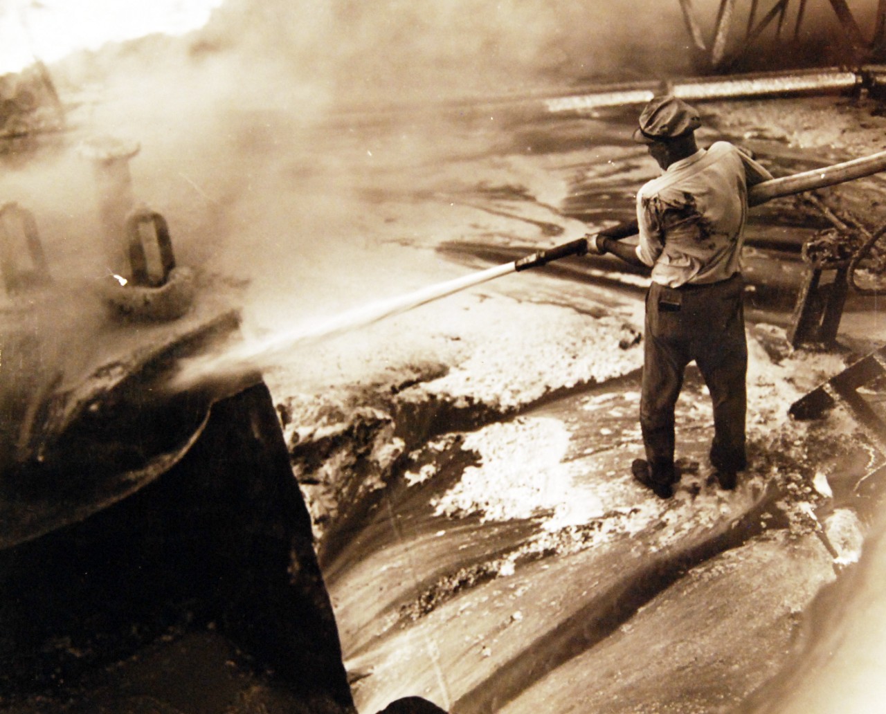 <p>80-G-61578: German U-boat attacks, WWII. SS Pennsylvania Sun burning after being torpedoed amidships by a torpedo by U-571 on July 15, 1942. Shown: Using foamite on oil fire.&nbsp;</p>
