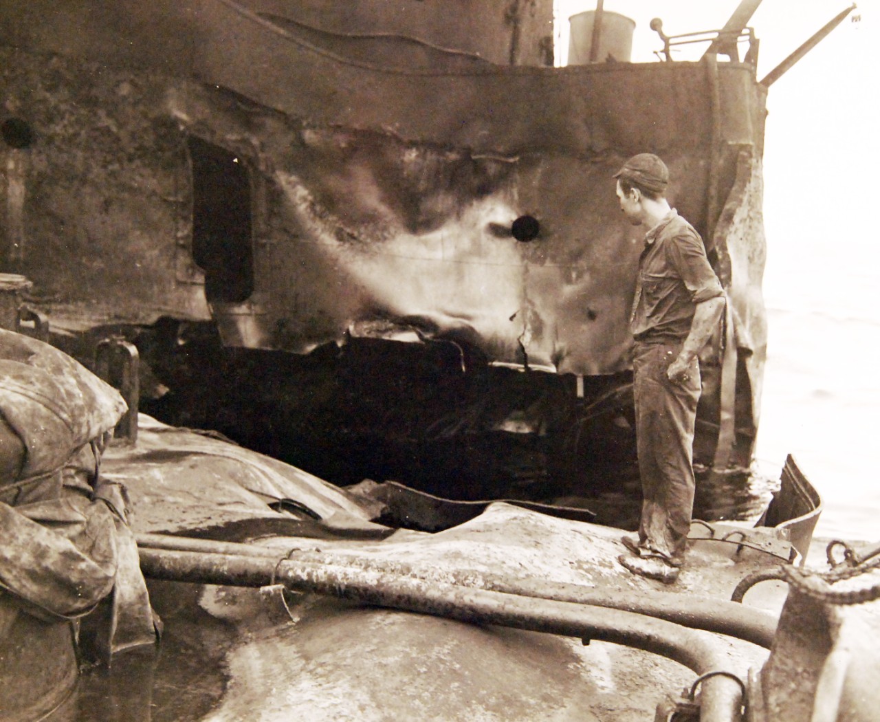 <p>80-G-61582: German U-boat attacks, WWII. SS Pennsylvania Sun burning after being torpedoed amidships by a torpedo by U-571 on July 15, 1942. Shown: Oil fire smothered showing damage to deck and bulkheads.&nbsp;</p>
