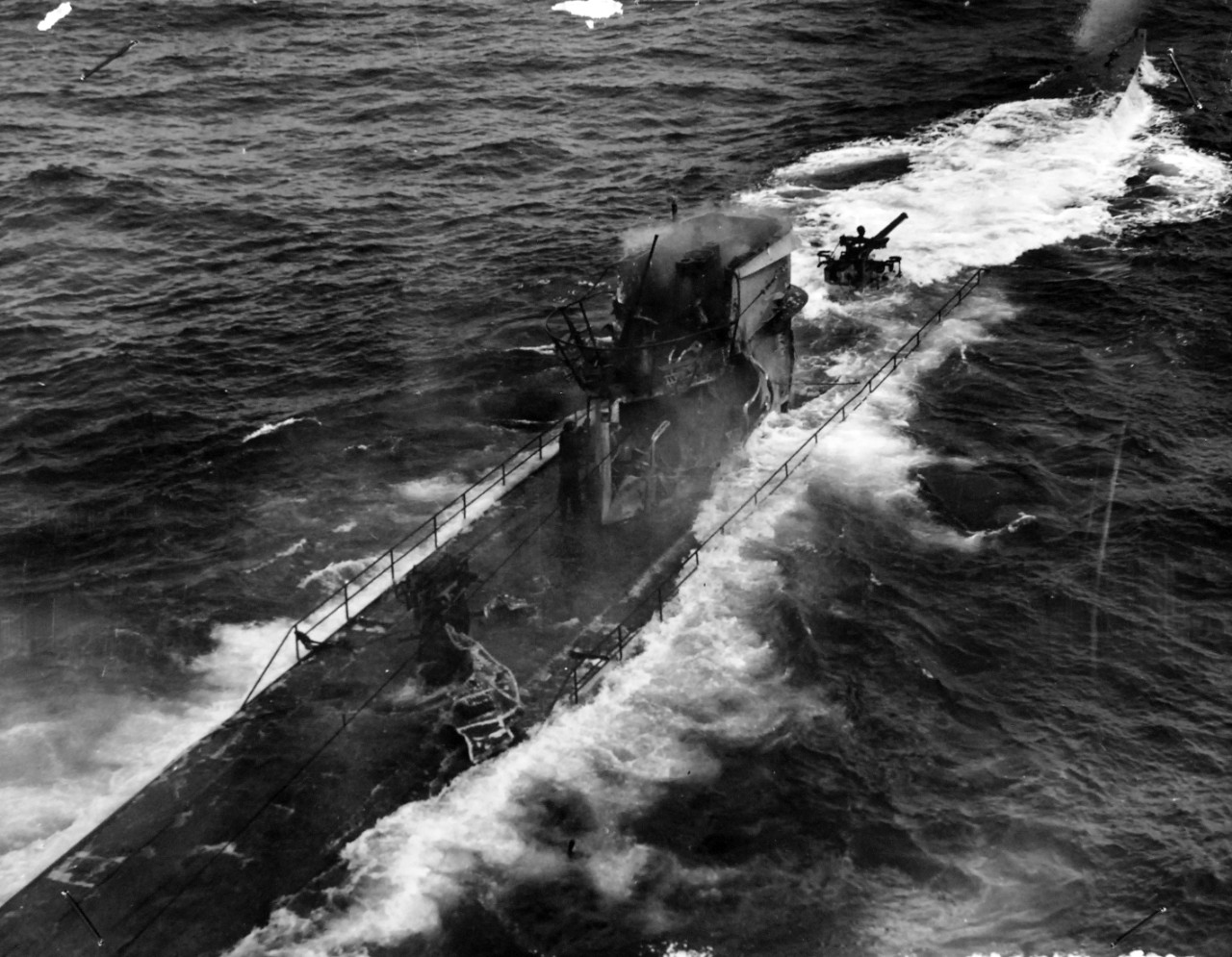 26-G-1512:  Sinking of German submarine U-175, April 1943.   The submarine was sunk off south-west of Ireland by USCGC Spencer (WPG-36) on April 17, 1943.  .  Original caption, “NAZI SUBMARINE SUNK BY THE FAMED CUTTER USCGC SPENCER (WPG-36): Effect of the U.S. Coast Guard Cutter USCGC SPENCER (WPG-36)'S fire are visible in this close-up shot of the U-Boat, taken as the battle raged.  The Nazi standing by the stanchion amidships disappeared a moment after this picture was taken by a Coast Guard photographer.  The U-Boat had been trying to sneak into the center of the convoy.”  Official U.S. Coast Guard Photograph, now in the collections of the National Archives.  (2017/09/05).