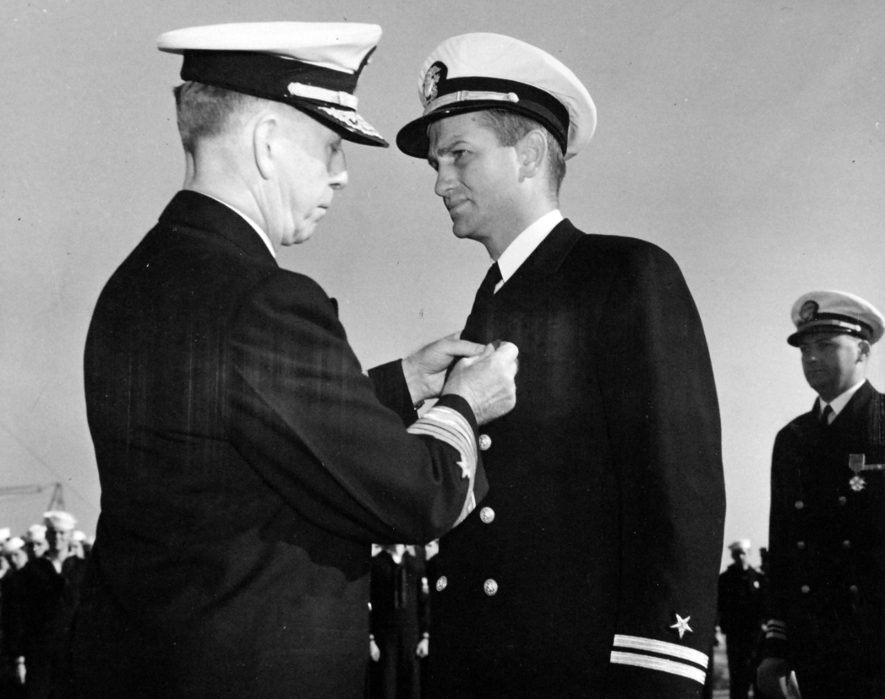 <p>80-G-43654: Sinking of German U-boat, U-405. Lieutenant Chas H. Hutchins, USNR, on the flight deck of USS Card (CVE-11) as Admiral Royal E. Ingersoll, USN, Commander-in-Chief of the Atlantic Fleet, pins on his chest the Navy Cross. Hutchins commanded the heroic USS Borie (DD 215), sinking German submarine U 405 on November 1, 1943. The award was made recently at an East Coast port on the occasion of the conferring of the Presidential Unit Citation on the Card, her air squadrons and her escorting destroyers. Photograph released November 10, 1943.&nbsp;</p>
