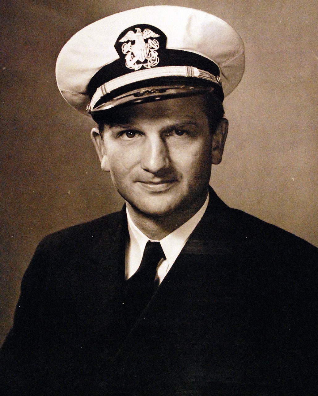 <p>80-G-43657: Sinking of German U-boat, U-405. Lieutenant Charles H. Hutchins, USNR, Commanding Officer of USS Borie (DD 215) who received the Presidential Unit Citation ribbon in recognition of the work of his destroyer, part of a task unit, which included USS Card (CVE-11). He received the Navy Cross at the same time. Hutchins’ vessel came upon two submarines on a dark, stormy night, miles from the other vessels and attacked immediately. The Borie rammed the other and sat astride, pumping shells into her conning tower from every gun that could be manned, from shotgun to big rifles. So close was the range, running from 10 to 40 feet, that even one knife hit was scored on a member of the Nazi gun crew. The submarine sank on November 1, 1943, but the Borie was mortally wounded and had to be abandonded and destroyed the following day. Photograph released November 11, 1943.&nbsp;</p>
