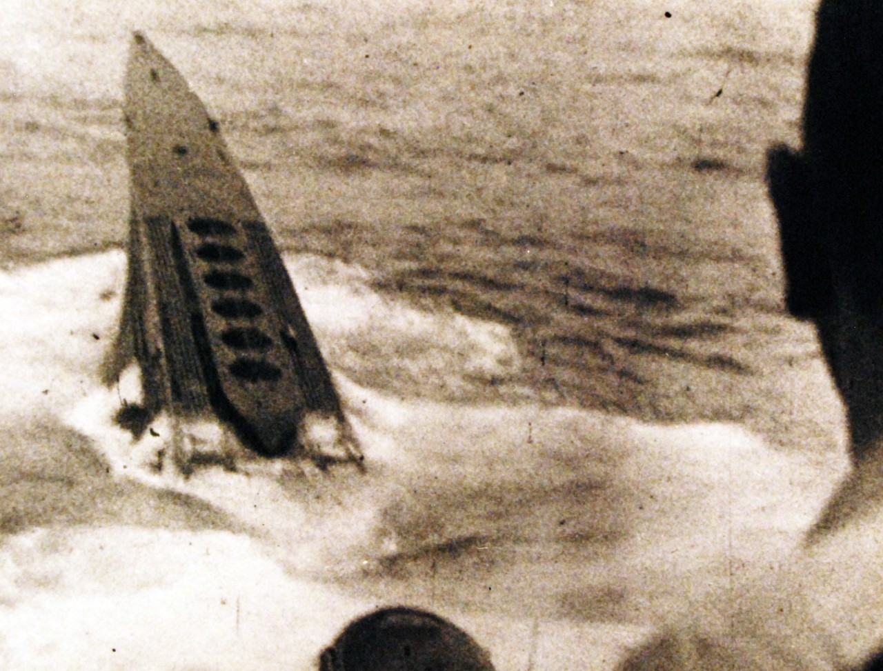 <p>80-G-700007: Battle of the Atlantic. U-233 (German Type XB Submarine) sinking after being rammed by USS Thomas (DE 102) in the North Atlantic, 5 July 1944. Photographed from Thomas’ bridge. Note mine chutes on the submarine’s foredeck, a feature of the type XB U-Boats.&nbsp;</p>
