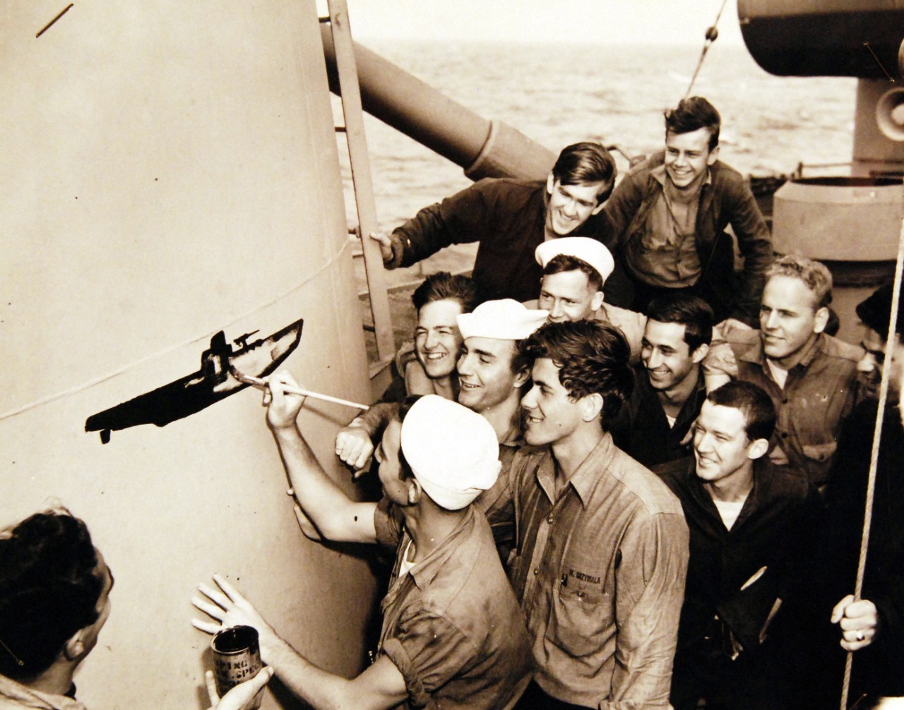 26-G-4451:    Sinking of German U-boat, U-853, May  1945.     Scratch another German U-Boat.   Jubilant over blasting a German submarine to the bottom in a recent sea fight, Coast Guardsmen aboard USS Moberly (PF-63) gather around the scoreboard to chalk up the victory.  Image pertains to U-boat, U-853.       Official U.S. Coast Guard Photograph, now in the collections of the National Archives.  (2017/09/05).  