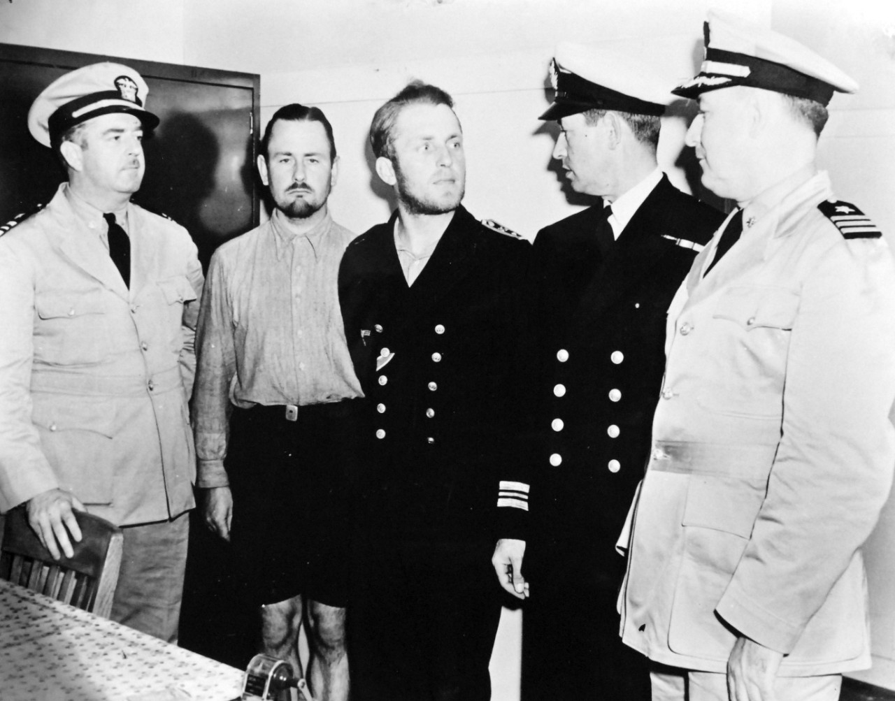 26-G-51543(4): German U-boat, U-352, May 1942.    German Officers, center, ignoring a British officer, continue their conversation at Charleston Navy Yard, South Carolina.  Their submarine was sunk by USCGC Icarus (WPC-110), May 9, 1942 Official U.S. Coast Guard Photograph, now in the collections of the National Archives.  (2017/09/05).