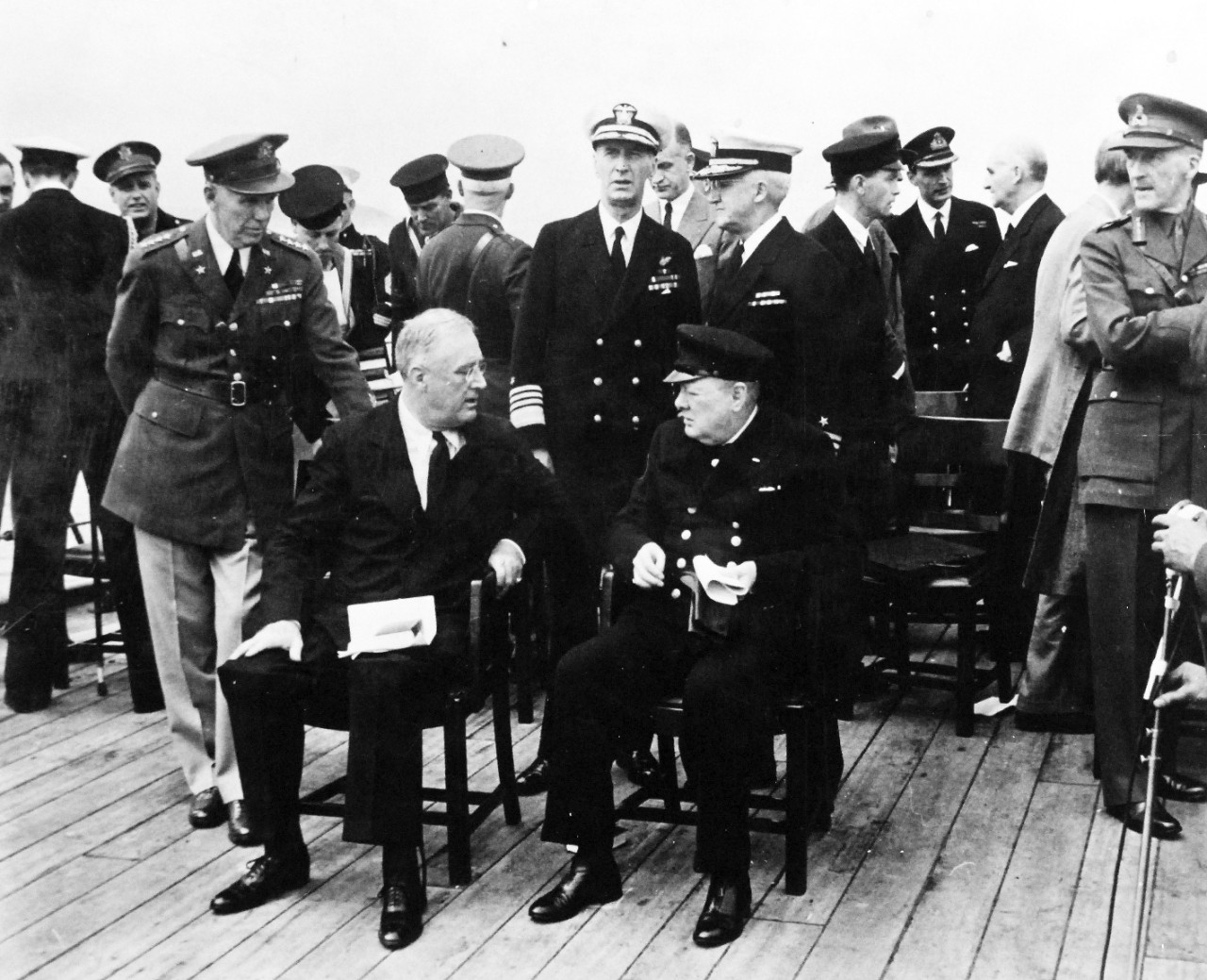 80-G-26847: Atlantic Charter, August 1941.  Informal group on deck of Royal Navy King George V battleship Prince of Wales following church services, during the Atlantic Charter meeting.  Standing behind President Franklin D. Roosevelt and Prime Minister Winston S. Churchill are General George C. Marshall, Admiral Ernest J. King, Admiral Harold R. Stark and General Sir John Dill.   Photograph released August 10, 1941.   Official U.S. Navy Photograph, now in the collections of the National Archives.  (2016/03/22).