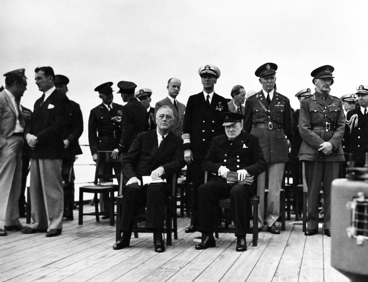 80-G-26848: Atlantic Charter, August 1941.  Informal group on deck of Royal Navy King George V battleship Prince of Wales following church services, during the Atlantic Charter meeting.  Sitting:  President Franklin D. Roosevelt and Prime Minister Winston S. Churchill.  Standing directly behind:  Admiral Ernest J. King;  General George C. Marshall; and General Sir John Dill.   Photograph released August 10, 1941.   Official U.S. Navy Photograph, now in the collections of the National Archives.  (2016/03/22).