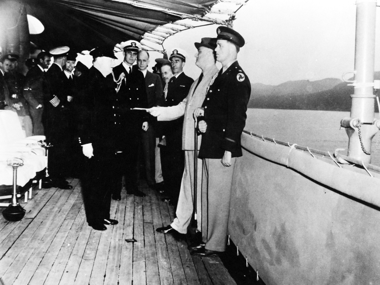 80-G-26861: Atlantic Charter, August 1941.  Prime Minister Winston S. Churchill and party coming onboard USS Augusta (CA-31) during the Atlantic Charter meeting.  Shown:   President Roosevelt receives a message from His Majesty King George VI.   Photograph released August 1941.   Official U.S. Navy Photograph, now in the collections of the National Archives.  (2016/03/22).