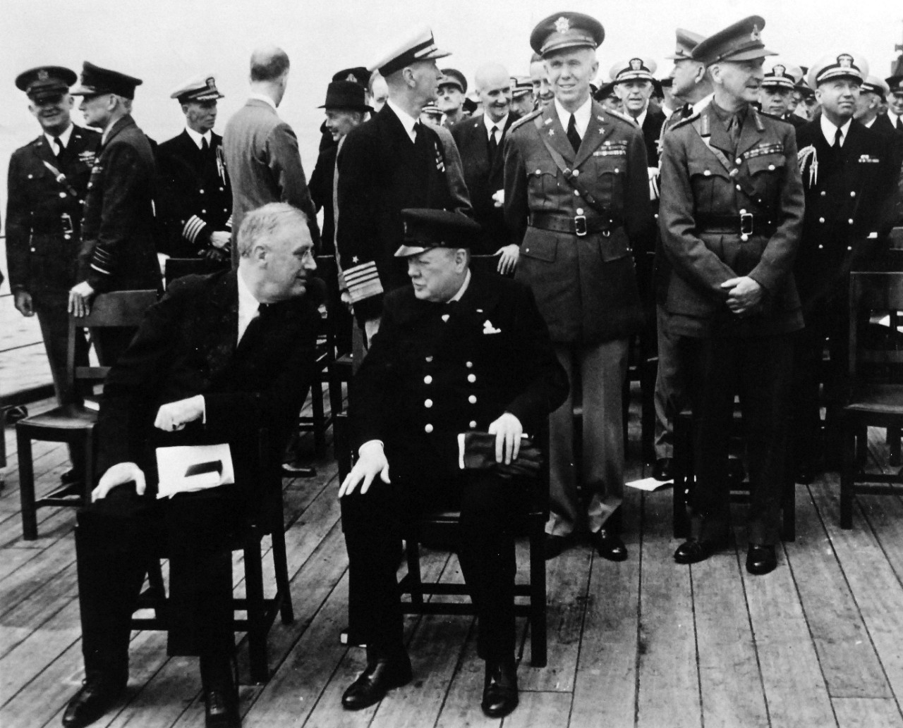 80-G-26863: Atlantic Charter, August 1941.  Informal group photograph including President Franklin D. Roosevelt and Prime Minister Winston S. Churchill on deck of HMS Prince of Wales following church services during the Atlantic Charter.  Photograph released August 1941.   Official U.S. Navy Photograph, now in the collections of the National Archives.  (2016/03/22).