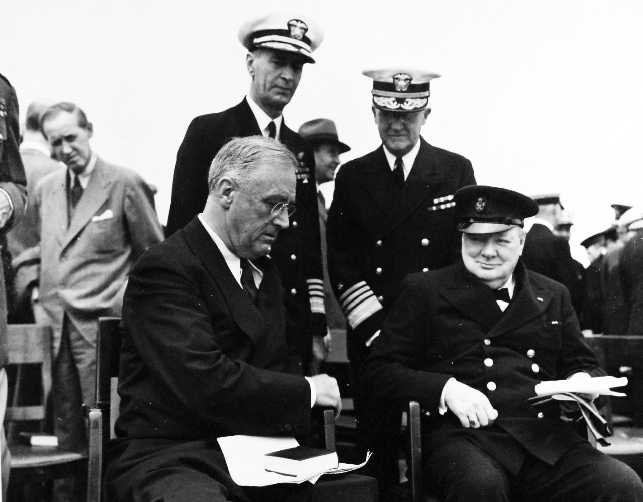 80-G-26865: Atlantic Charter, August 1941.  Informal group photograph including President Franklin D. Roosevelt and Prime Minister Winston S. Churchill on deck of HMS Prince of Wales following church services during the Atlantic Charter.  Left to right:  Harry Hopkins; Admiral Ernest J. King; Admiral Harold R. Stark.  Photograph released August 1941.   Official U.S. Navy Photograph, now in the collections of the National Archives.  (2016/03/22).
