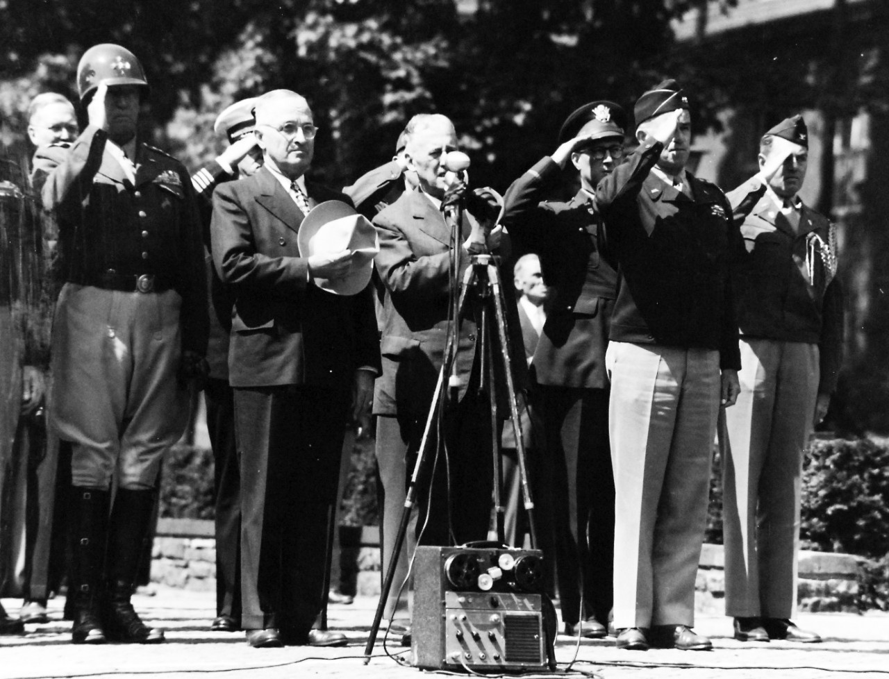 80-G-700072:   U.S. Navy in Germany, 1945.   President Harry S. Truman attends flag-raising ceremony in Berlin, Germany.   At attention while National Anthem is being played.  Left to right: Brigadier General Harry Vaughn, Military Aide; General George S. Patton; President Harry S. Truman; Secretary of War Harry Stimson and General Omar W. Bradley.     Photographed by CPhom William Belknap, Jr., July 20, 1945.   Official U.S. Navy photograph, now in the collections of the National Archives.  (2017/02/14).  