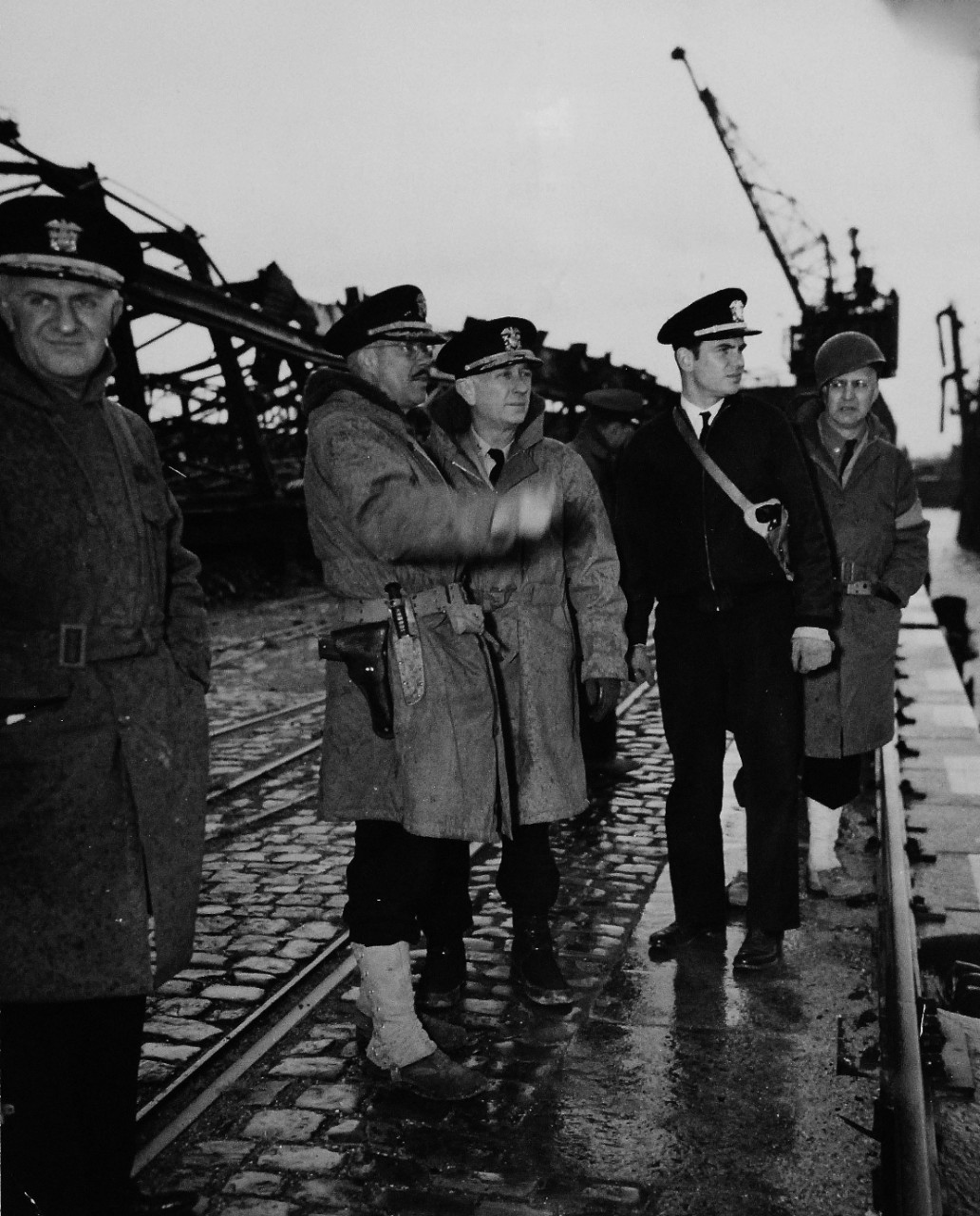 80-G-49281:   U.S. Navy in Germany, 1945.   Transported 400 miles across Europe by U.S. Army, a force of Naval Officers and men take over administration of port activities of Bremen, Germany.   Damaged but readily repairable facilities are inspected by command staff of U.S. Navy.  Captain V.H. Coufrey points out salient features of Europe Hafen Docks to Rear Admiral Arthur G. Robinson.   Photograph released May 29, 1945.   Official U.S. Navy photograph, now in the collections of the U.S. Navy.   (2014/12/02).   