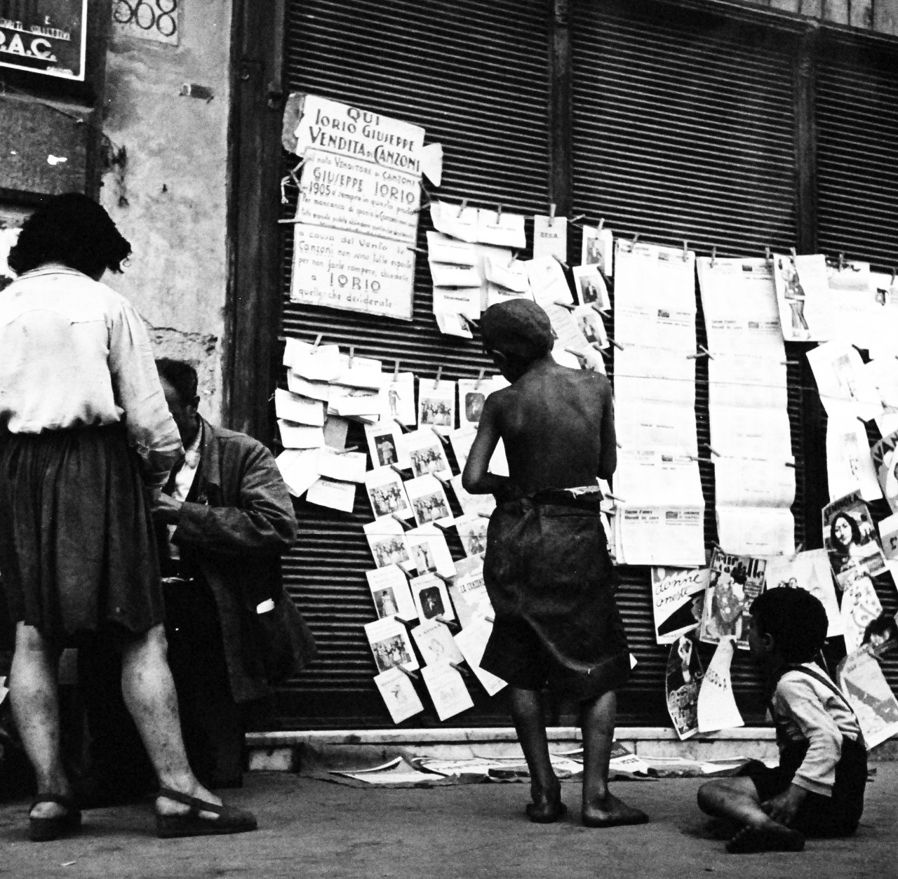 80-G-474147:  Naples, Italy, August 1944.    Reading notices. Steichen Photograph Unit:  Photographed by Lieutenant Wayne Miller, August 1944.  TR-13034.   U.S. Navy Photograph, now in the collections of the National Archives. (2015/12/08). 