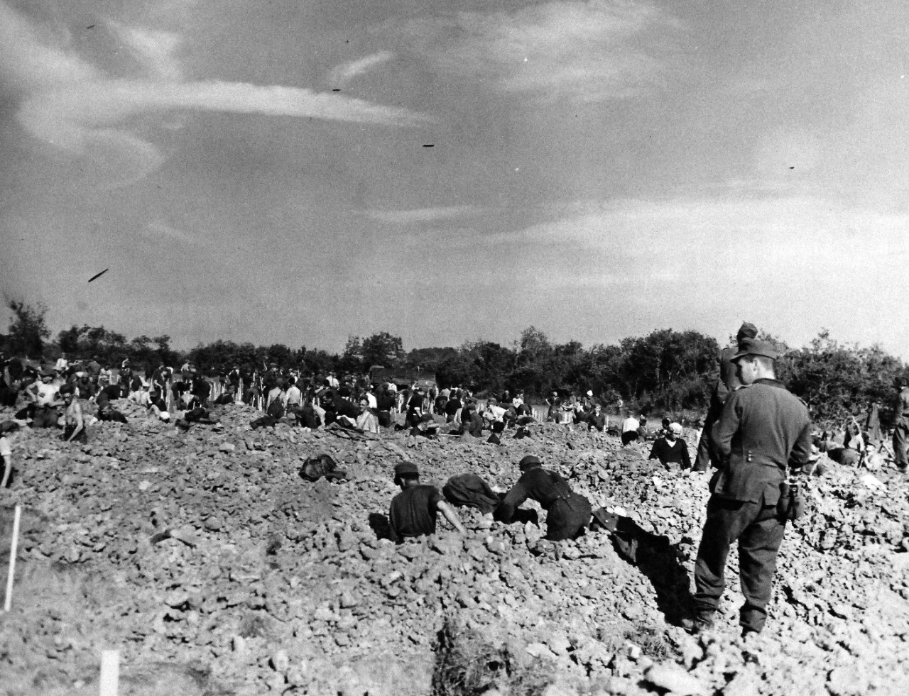 80-G-285231:  Normandy Invasion, German Prisoners, June 1944. German prisoners, captured during invasion of Normandy, France, digging graves overlooking Dog Red beach.   Photograph released November 7, 1944.  U.S. Navy photograph, now in the collections of the National Archives.  (2016/03/15).