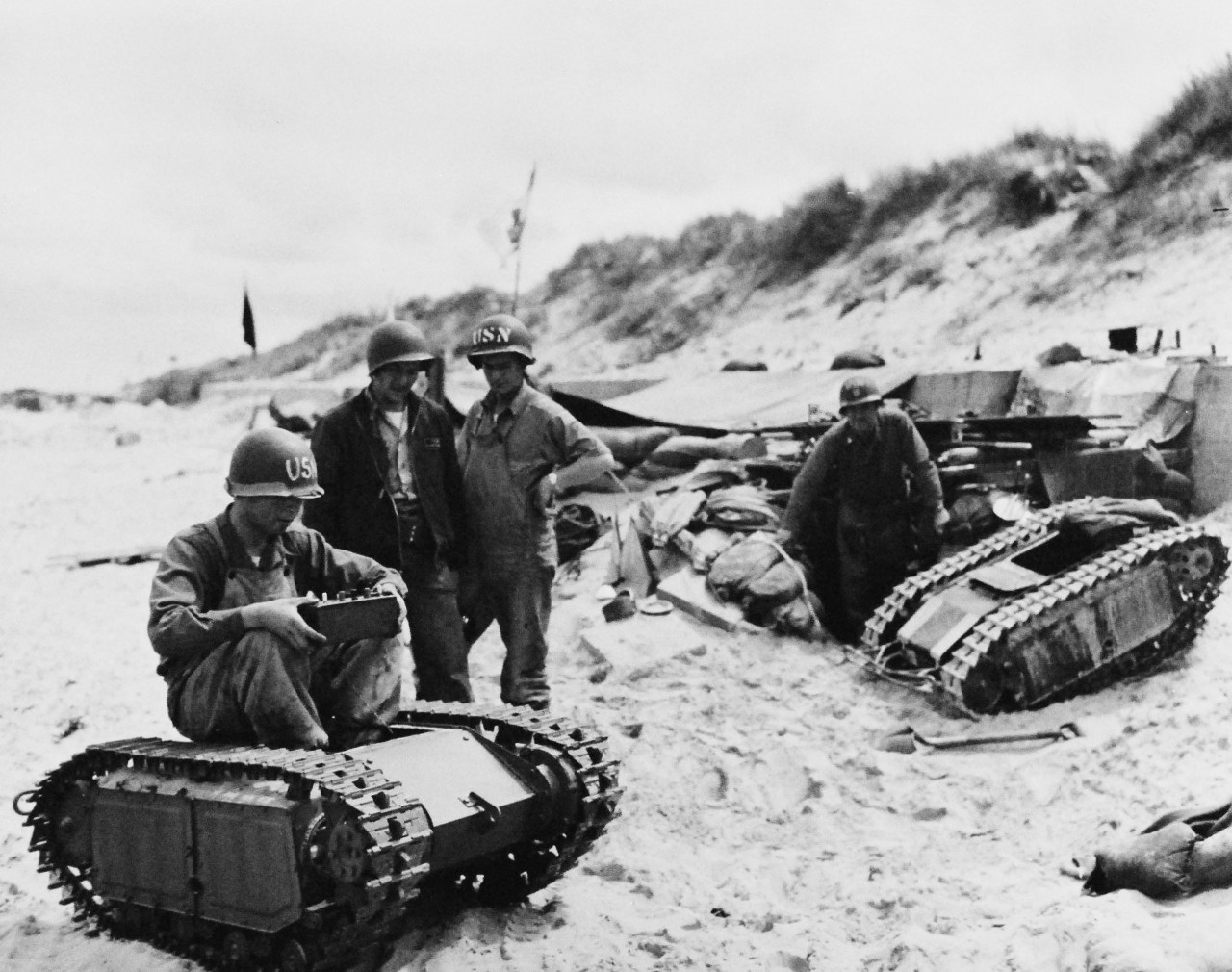 80-G-252746: Normandy Invasion,  Utah Beach, June 1944.  U.S. Navy 2nd Beach Battalion on “Utah” Beach, Bay of Seine, taking captured radio-controlled German “Beetle” tanks to see what makes them tick.   Photograph released, 11 June 1944.  Official U.S. Navy Photograph, now in the collections of the National Archives.   (2014/10/28). 