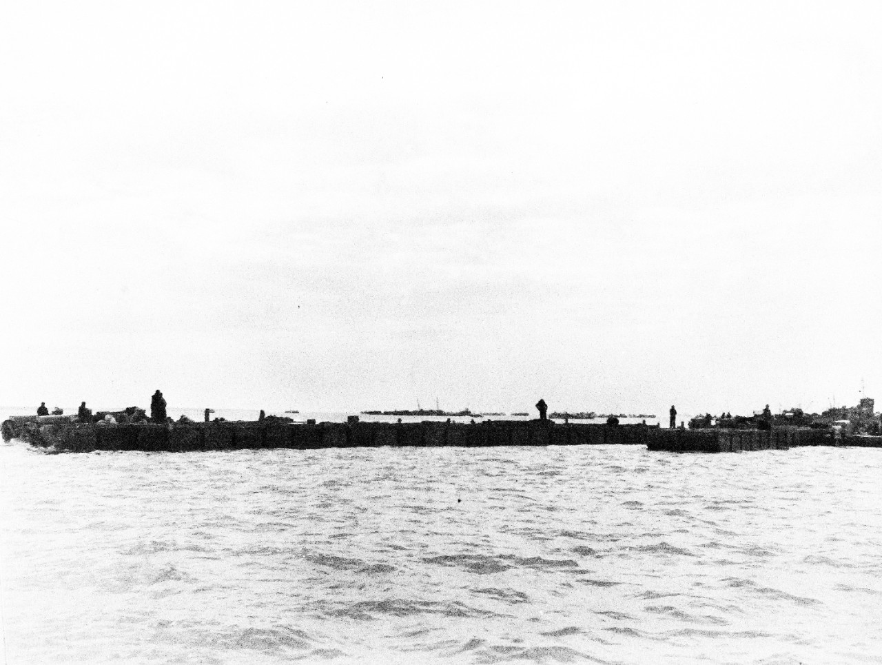 80-G-285178:  Normandy Invasion, Mulberries, June 1944.   Rhino barges carrying equipment to invasion beach of Normandy, France.  In the background is a section of “Gooseberry,” a purposely sunk ships forming part of the “Mulberry,” the man-made harbor.  Photograph released November 7, 1944.  Official U.S. Navy photograph, now in the collections of the National Archives.  (2016/03/15).