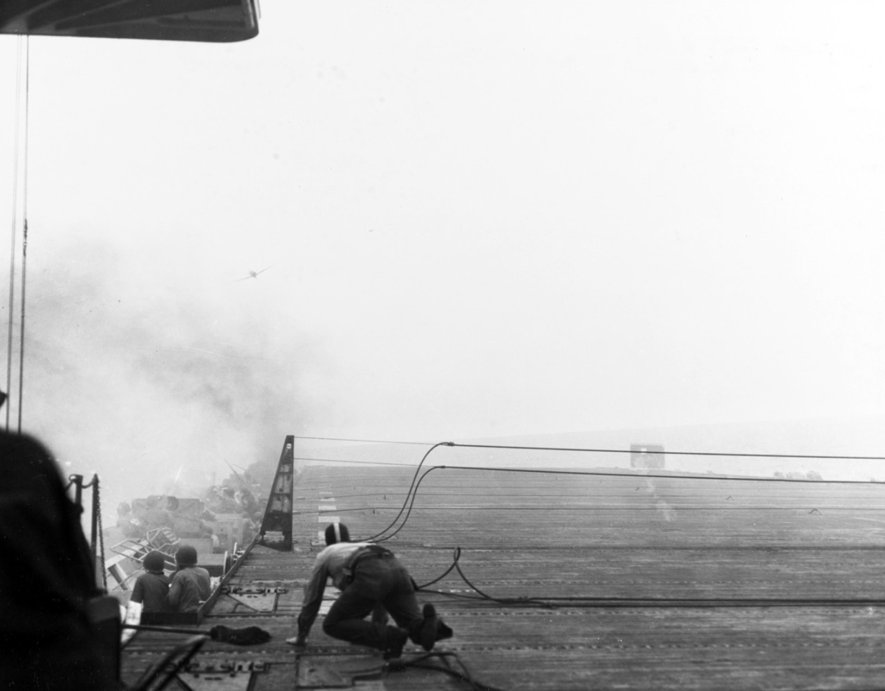 80-G-288881:  USS White Plains (CVE-66), October 25, 1944.  Battle of Leyte Gulf, Battle off Samar.  Japanese “Zeke” fighter attacking USS White Plains (CVE-66) off Samar.  Note, the plane crashed just off the ship’s port side.  Official U.S. Navy Photograph, now in the collections of the National Archives.  