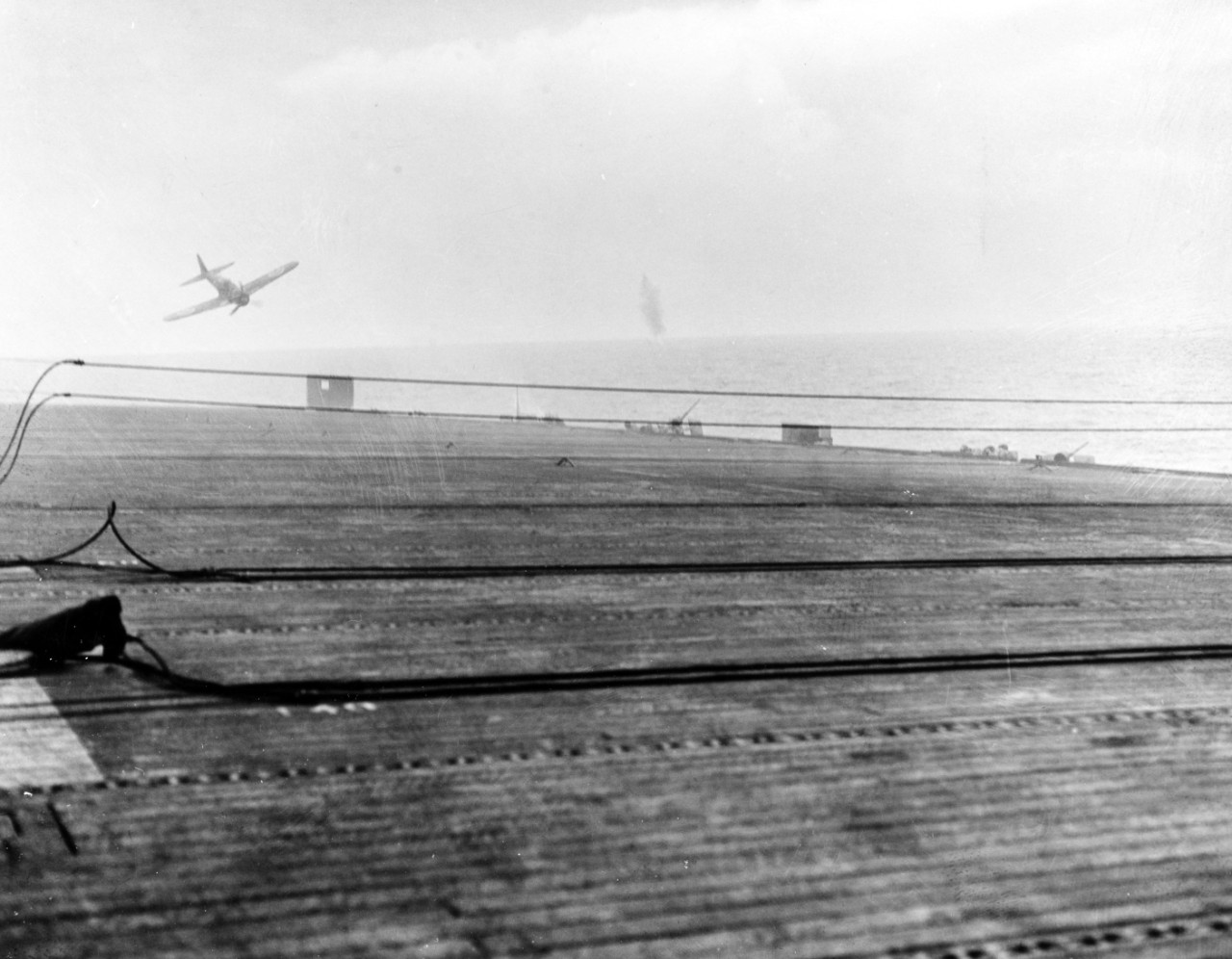 80-G-288882:  USS White Plains (CVE-66), October 25, 1944.  Battle of Leyte Gulf, Battle off Samar.  Japanese “Zeke” fighter attempting a kamikaze attack on USS White Plains (CVE-66) off Samar.  Note, the plane crashed just off the ship’s port side.  Official U.S. Navy Photograph, now in the collections of the National Archives.  