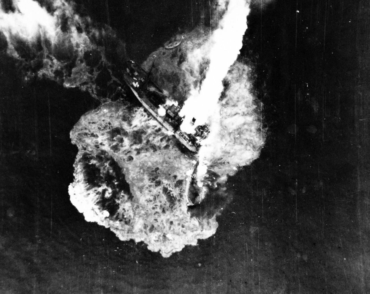 80-G-490116:  Raids on Japanese Home Islands, July 1945.   Japanese freighter snaps in two following a direct bomb hit from carrier-based aircraft of the Third Fleet.  The ship was bombed and destroyed near Tsugaru-Kaikyo, east of Hokkaido, Japan. An empty life boat can be seen at top, center, as the bow breaks away following an internal explosion, July 24, 1945.  U.S. Navy Photograph, now in the collections of the National Archives. (2015/12/08).