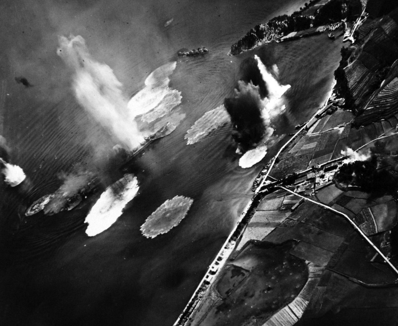 80-G-490147:   Raids on Japanese Home Islands, July  24, 1945.   Japanese cruiser Tone under air attack near Kure, July 24, 1945.  Photograph by USS Shangri-La (CV-38) aircraft.  Note anti-aircraft positions ashore.   U.S. Navy Photograph, now in the collections of the National Archives. (2015/12/08). 