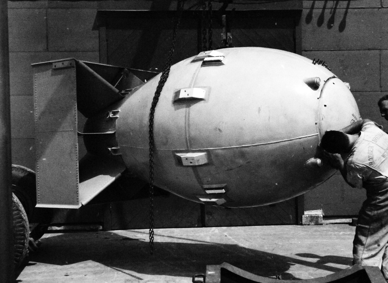 77-BT-183:   Tinian Island, August 1945.    Atomic Bomb, Fat Man, being worked on in cradle outside building #2.  Official photograph of the Office of Chief of Engineers, now in the collection of the National Achives.   (2015/08/25). 